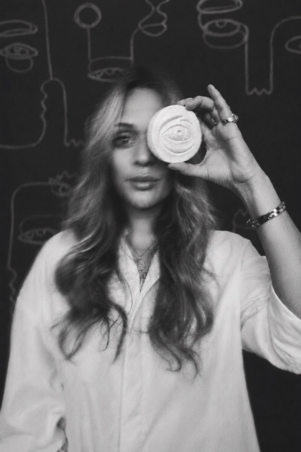 Black-and-white portrait of artist Adri Bru holding a ceramic eye